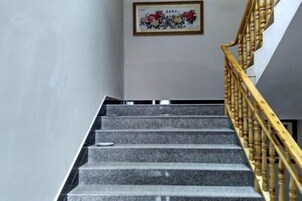 Una escalera con barandilla de madera y un cuadro en la pared.