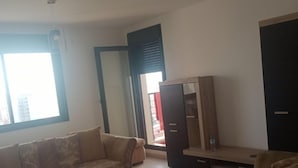 Una sala de estar con sofá, mesa de centro y mueble para televisión.