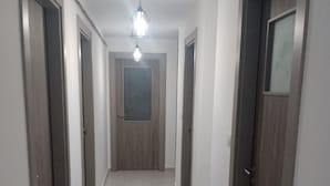 Un pasillo con puertas de madera y suelo de baldosas.