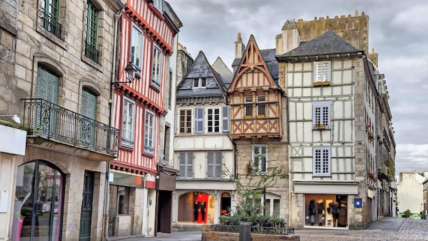 Una strada con edifici storici caratterizzati da architettura europea tradizionale, con strutture in legno e facciate in pietra.