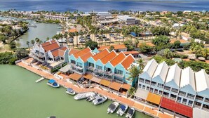 A coastal resort with multiple buildings, a marina, and a view of the ocean. - Caribbean Court Studio 321 with a refreshing shared pool and spectacular lagoon views (Kralendijk)