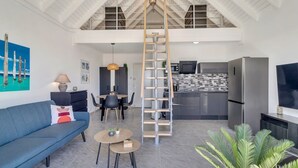 A spacious living area with a loft bedroom, a kitchen, and a dining area. - Caribbean Court Studio 321 with a refreshing shared pool and spectacular lagoon views (Kralendijk)