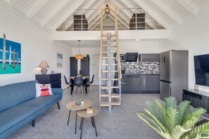 A spacious living area with a loft bedroom, a dining area, and a kitchen.