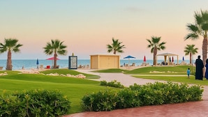 A beachside resort with palm trees, a pool area, and a view of the ocean. - Porto Said Seaview Unit (Port Said Governorate)