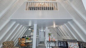 Un ático espacioso con comedor, cocina y zona de estar.
