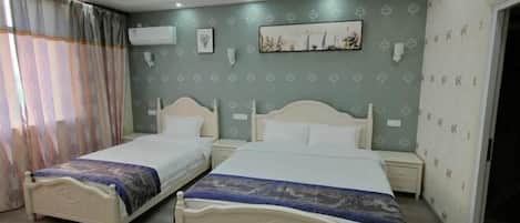 A hotel room with two beds, a large window with curtains, a wall-mounted air conditioner, and a framed picture.