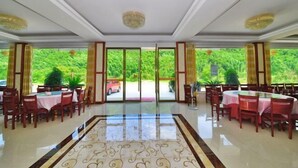 A spacious dining area with multiple tables and chairs, large windows offering a view of greenery outside. - Ningguo Julongwan Farmstay (Ningguo)
