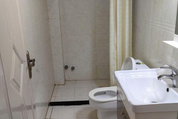 A bathroom with a toilet, sink, and shower area. - Ningguo Julongwan Farmstay (Ningguo)