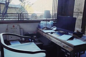 A room with a desk, computer, chair, and window with blinds. - Habuda Yungu Hostel (Weixi)