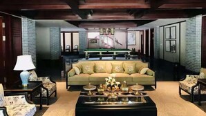 A spacious living area with a sofa, armchairs, and a coffee table.