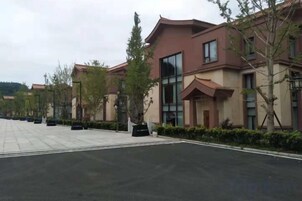 Un edificio moderno con techo plano, amplias ventanas y un camino de entrada pavimentado.