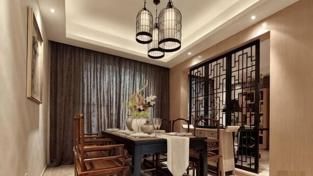 A dining area with a table set for four, wooden chairs, a vase with flowers, and a decorative screen.