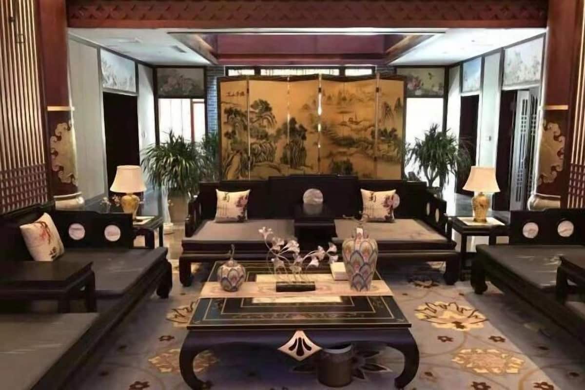 Un hall tradicional con un conjunto de sofás, una mesa de centro y objetos decorativos.