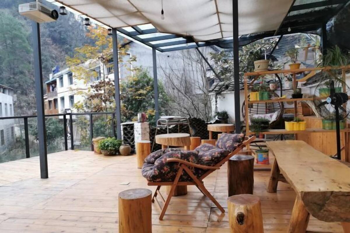 An outdoor seating area with a wooden table, a cushioned chair, and a wooden bench.