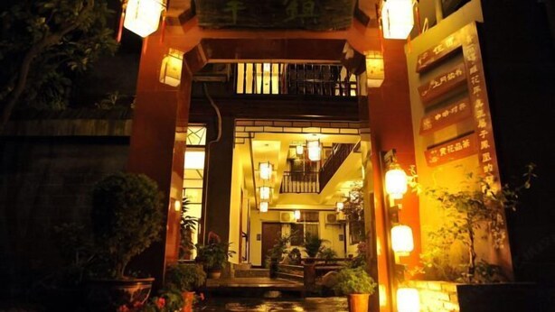 A traditional Japanese-style entrance with a wooden torii gate, lanterns, and potted plants. - Zhen'Gan Club (Fenghuang County)