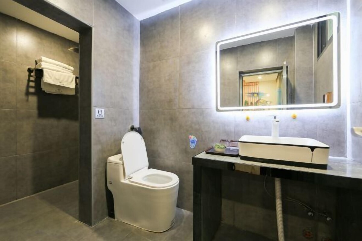 Ein modernes Badezimmer mit Toilette, Waschtisch mit Spiegel und Handtuchhalter.