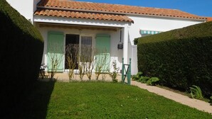 A house with a tiled roof, a small porch, and a well-maintained lawn. - Vendean house with private pool, near beach, 5 people (La Faute-sur-Mer)