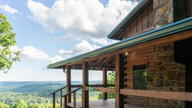 A wooden cabin with a stone exterior, a covered porch, and a scenic mountain view. - Windridge Cabin w/ Beautiful View (Ponca)