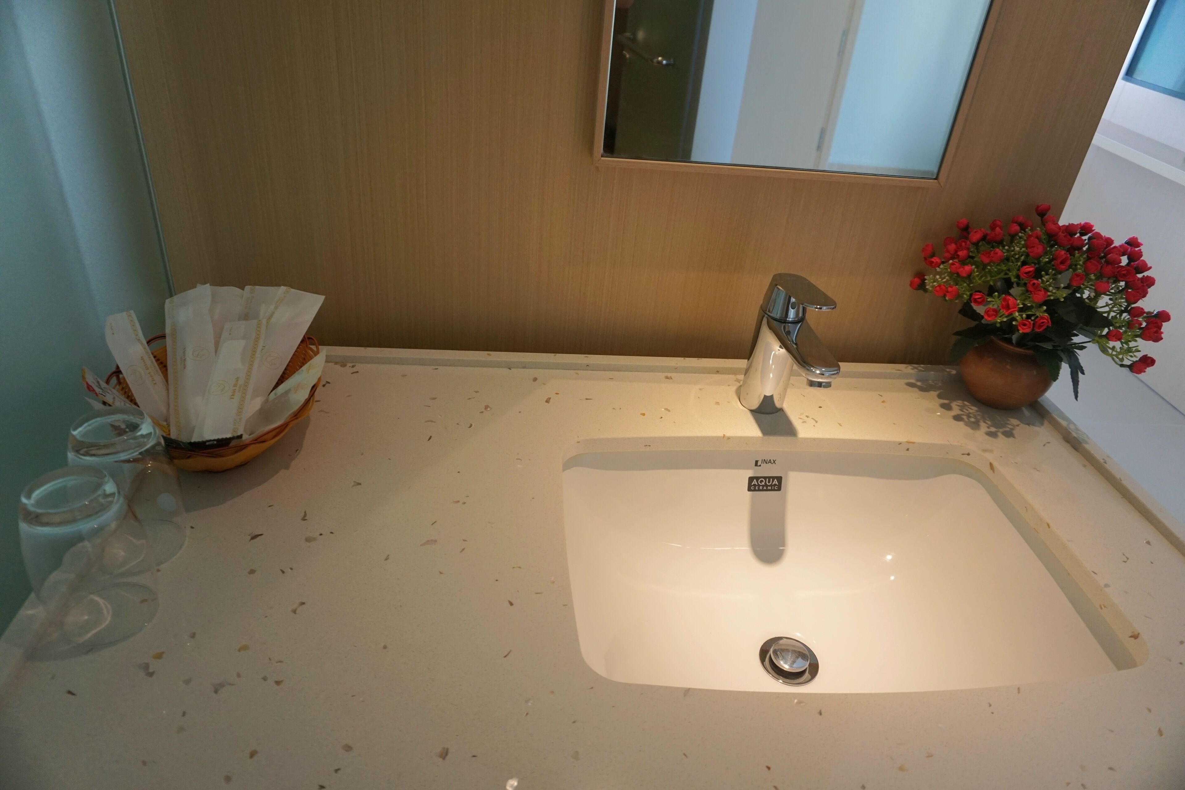 Ein Badezimmer mit Waschbecken, Spiegel und einer Zimmerpflanze.