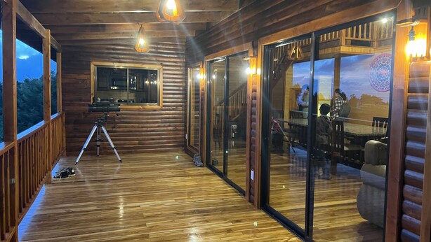 A wooden deck with a telescope, a glass door leading to a dining area, and a view of the outdoors. - Full house with breathtaking views (San José)