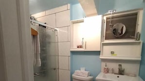 A bathroom with a shower, toilet, and sink. - Cottage at West 7 Palms  (St. Thomas)