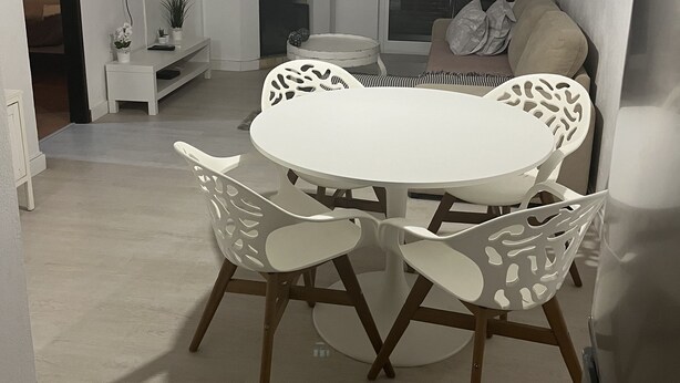 A dining area with a round table and chairs, a television on the wall, and a fireplace. - Apartment center Albufeira (Albufeira)