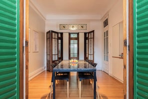 A dining area with a marble table, wooden chairs, and a decorative glass partition.