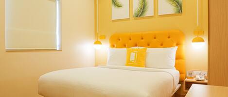 A bedroom with a large bed, a wooden headboard, and a bedside table.