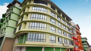 A multi-story building with a curved facade, large windows, and balconies. - Hotel Gajraj (Gangtok)