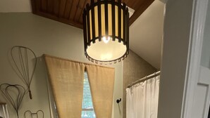 Ein Badezimmer mit Toilette, Duschvorhang und einem fenster mit Vorhängen.