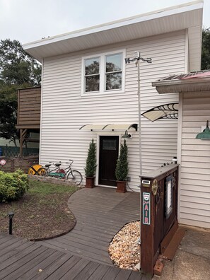 A house with a covered porch, a bicycle, and a mailbox.