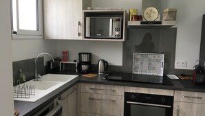 A modern kitchen with a built-in microwave, coffee maker, and dishwasher. - Classified 4★ Landes house with swimming pool, in town center and beach nearby. (Messanges)