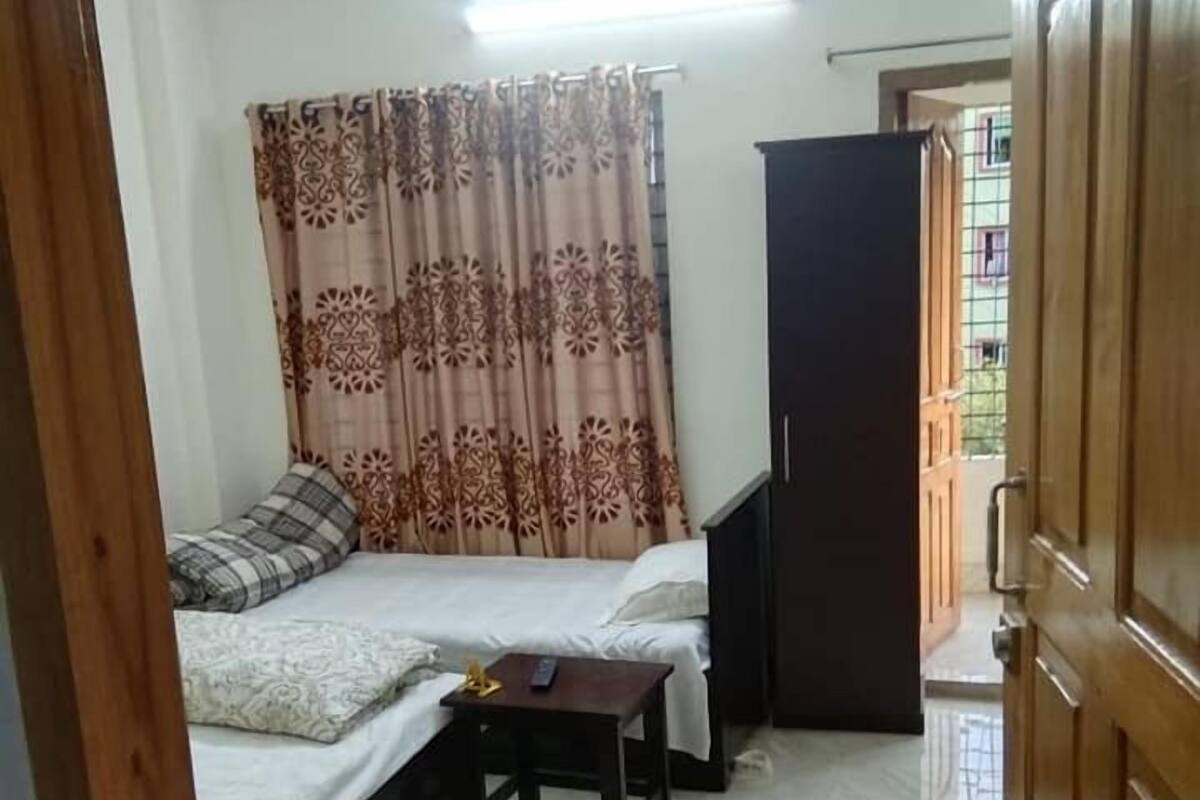 A compact room with a bed, a small table, and a wardrobe.