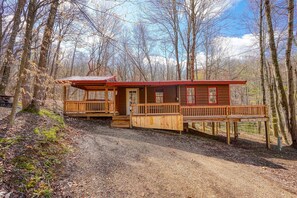 Eine rustikale Holzhütte mit einer Holzterrasse, einer Veranda und einem kleinen Sitzbereich.