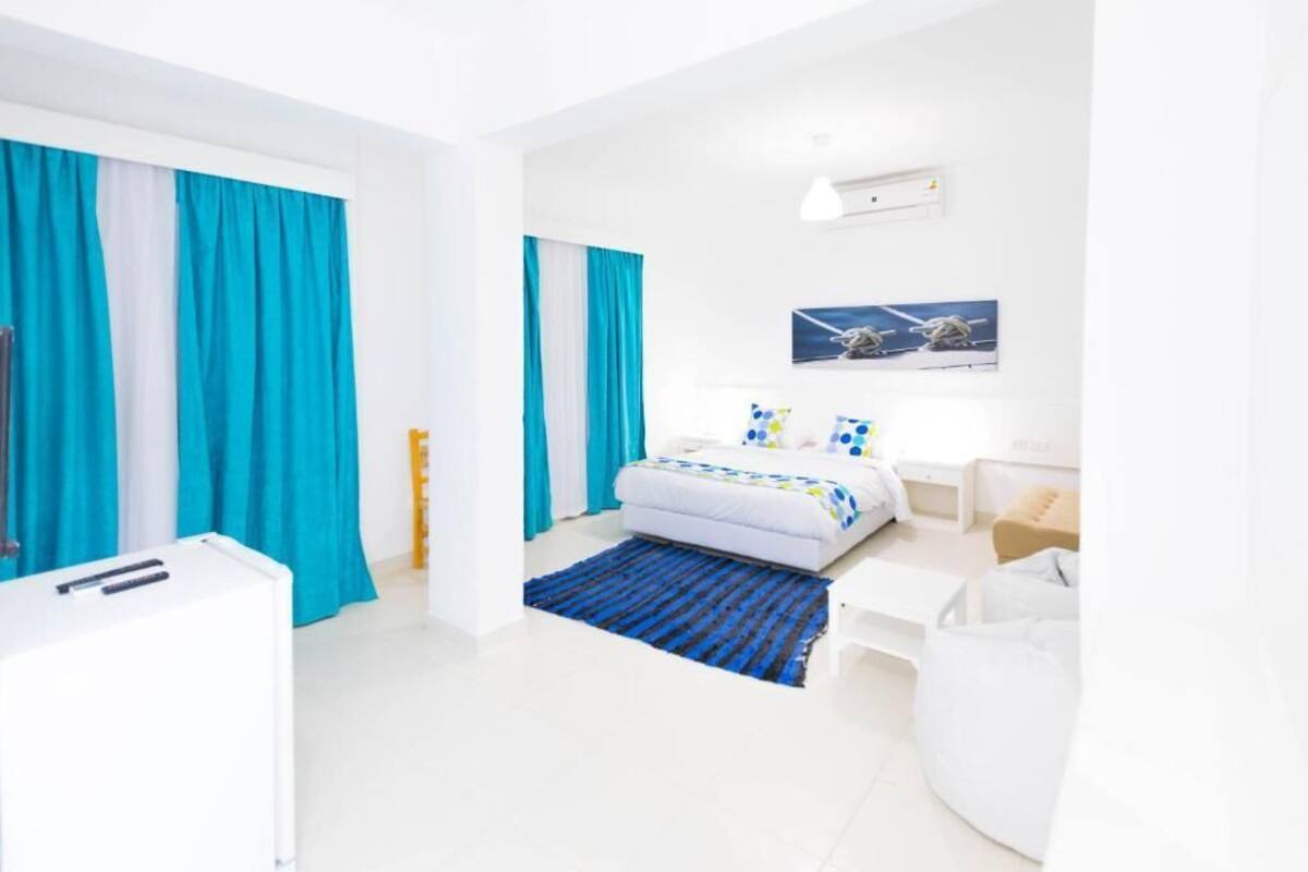 A modern hotel room with a bed, a desk, and a chair.