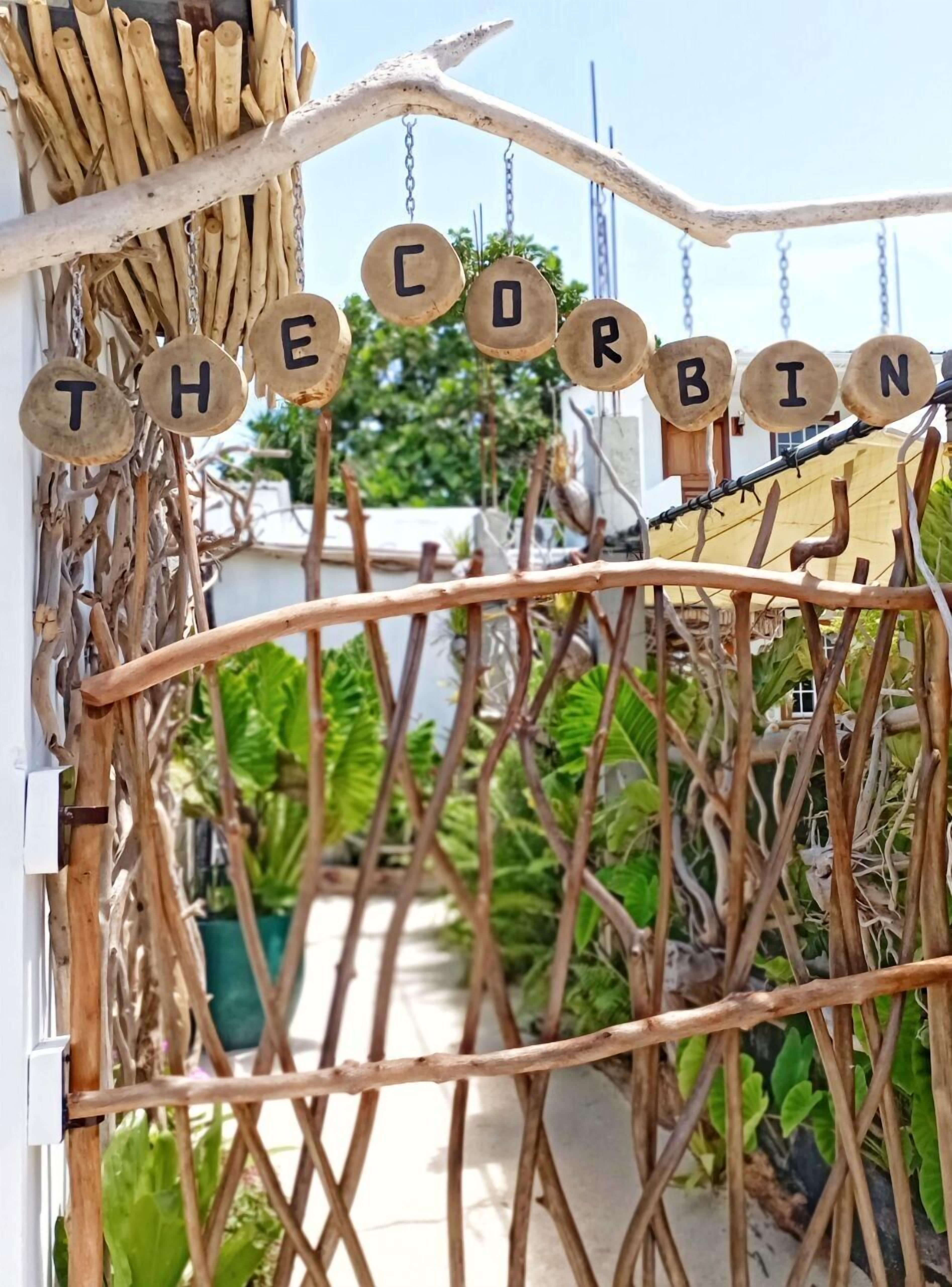 A gate with wooden letters spelling "THE CORBIN" and a rustic gate design.
