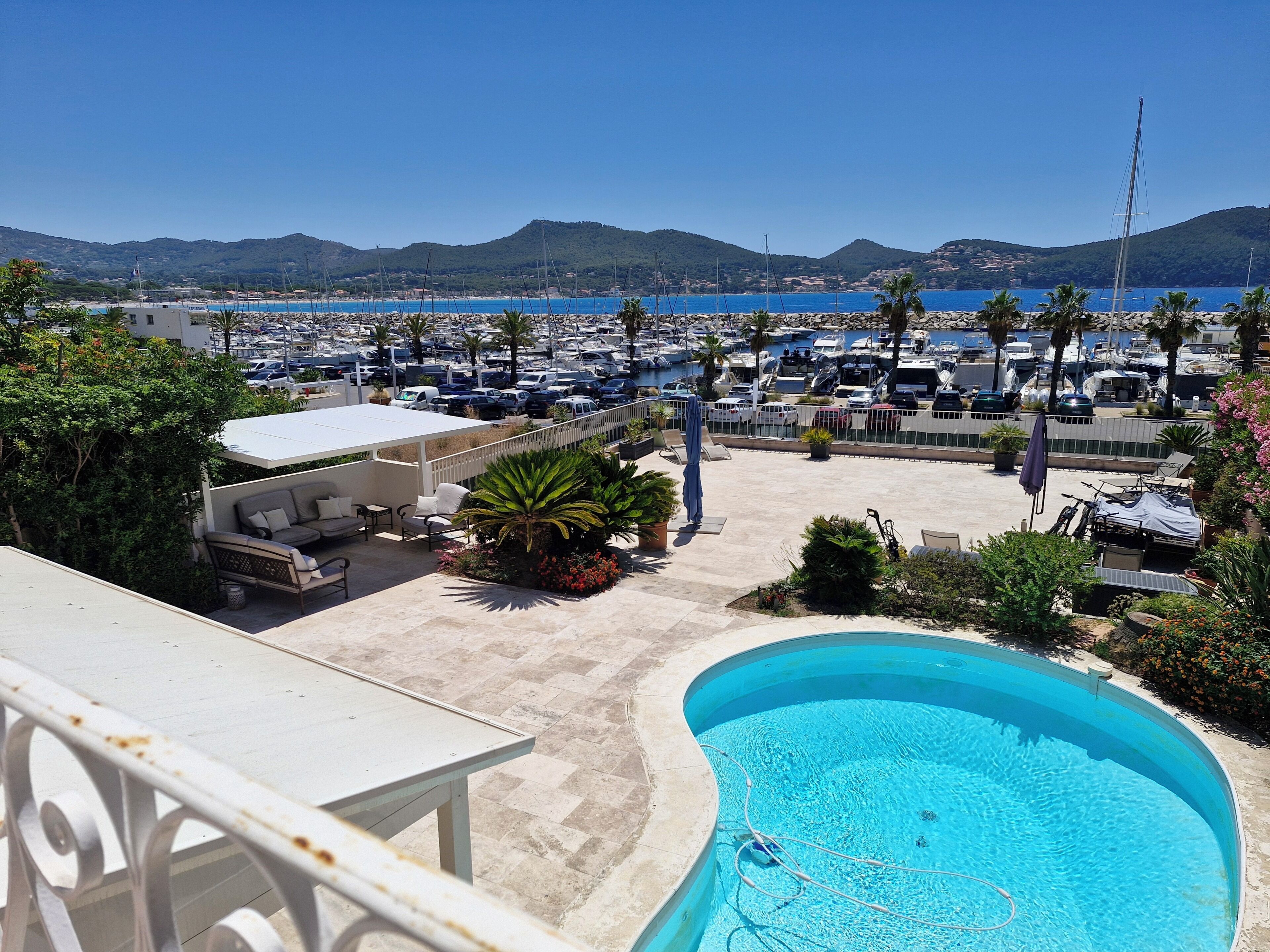 A pool area with a view of the marina and hills.