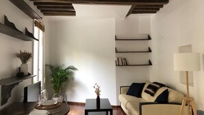 Un salon moderne avec un plafond en bois, un canapé, une table basse et une lampe.