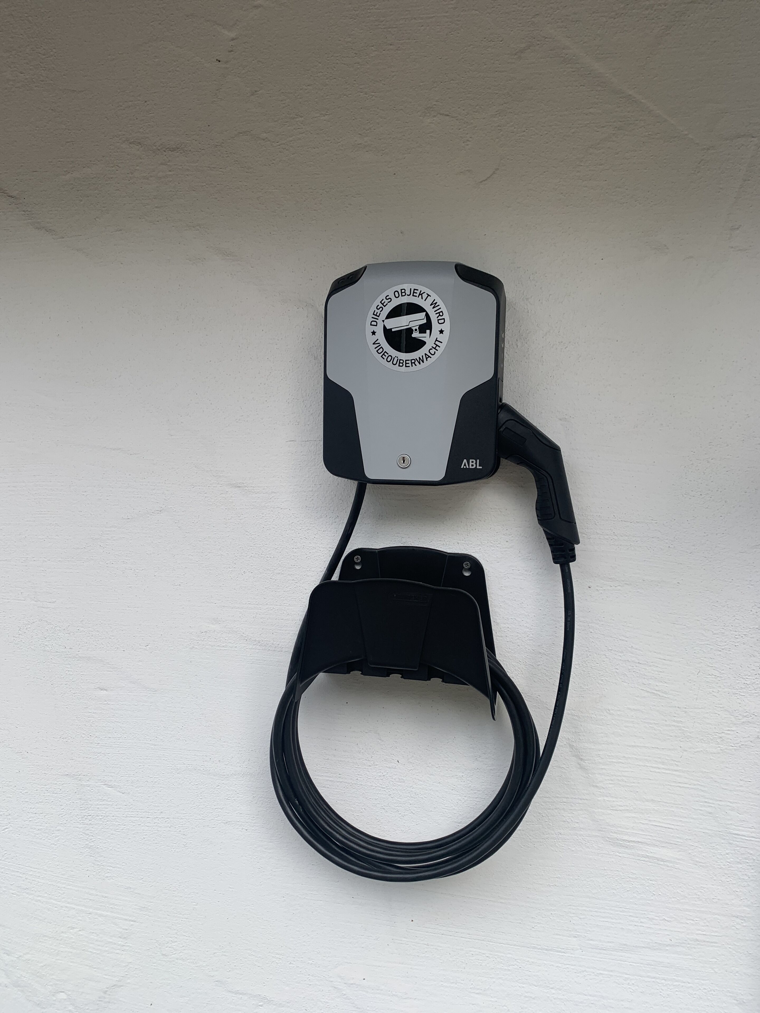 Un dispositivo negro y gris con un cable y una correa, etiquetado como "Abl".