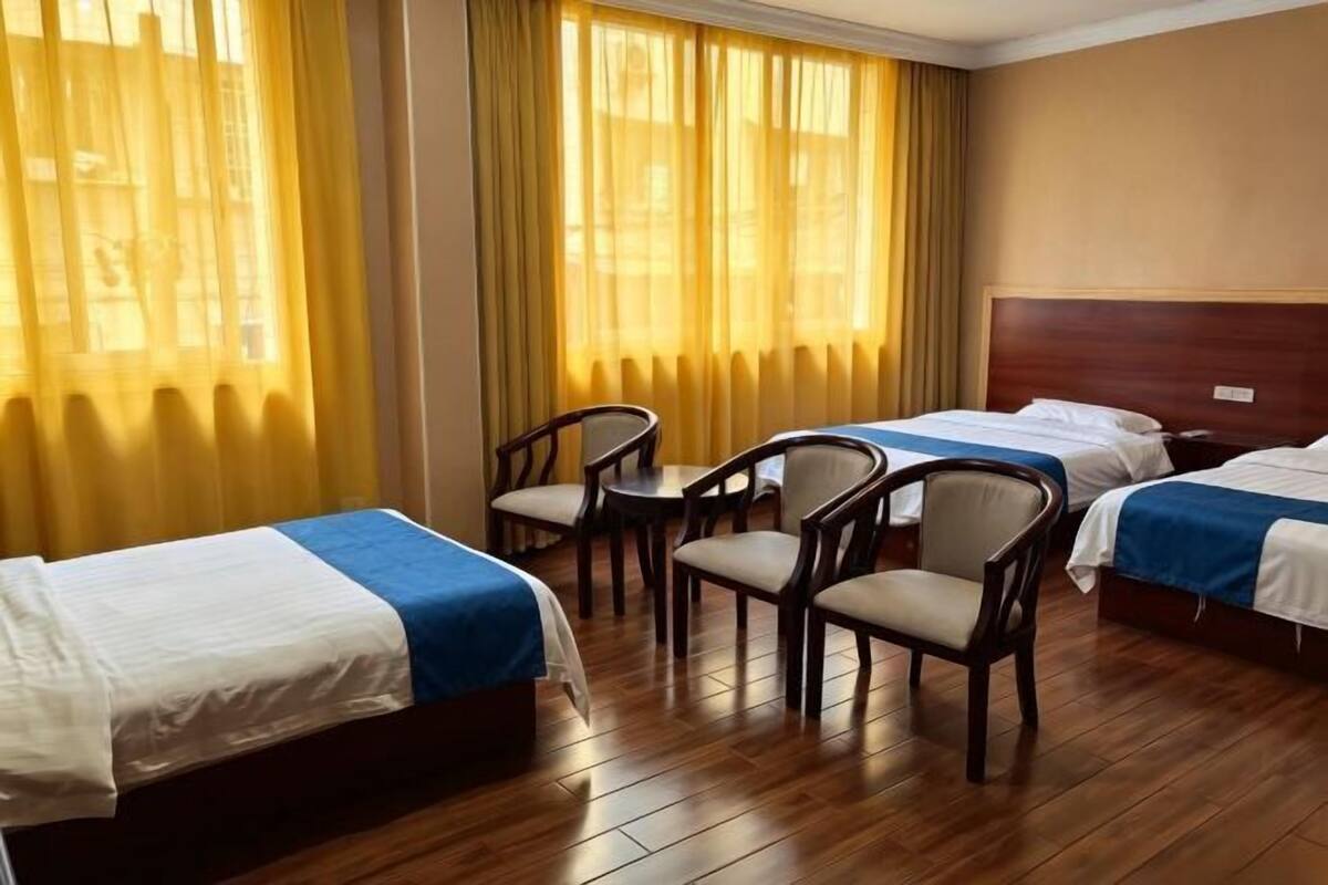 A hotel room with two beds, a small table, and two chairs.