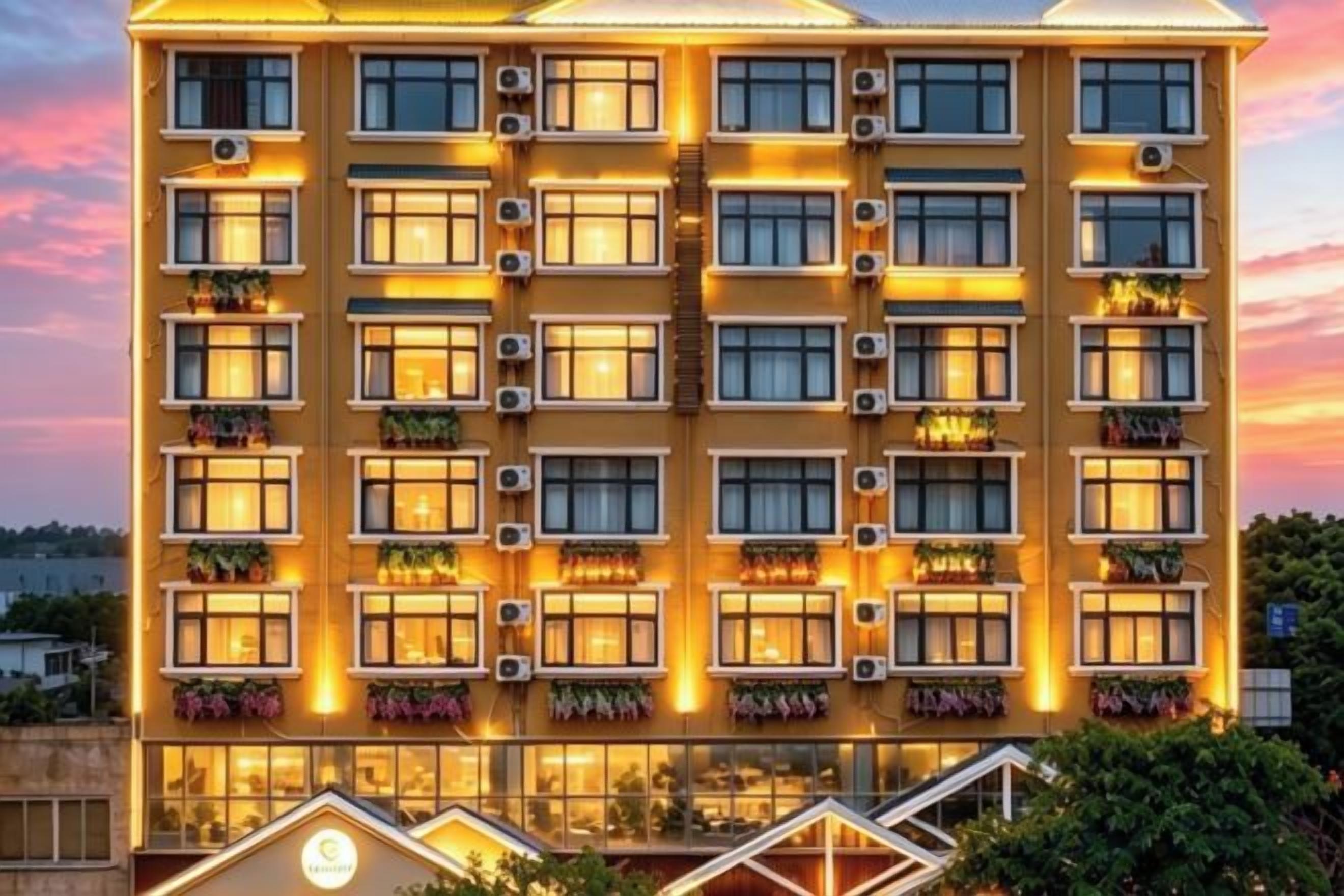 A multi-story hotel with balconies, air conditioning units, and a well-lit facade.