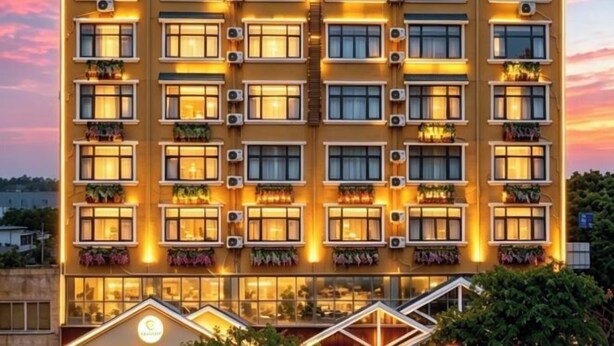 A multi-story hotel with a uniform facade, air conditioning units, and balconies with plants. - Jindalai Tianyuan Hotel (Xing'an County)