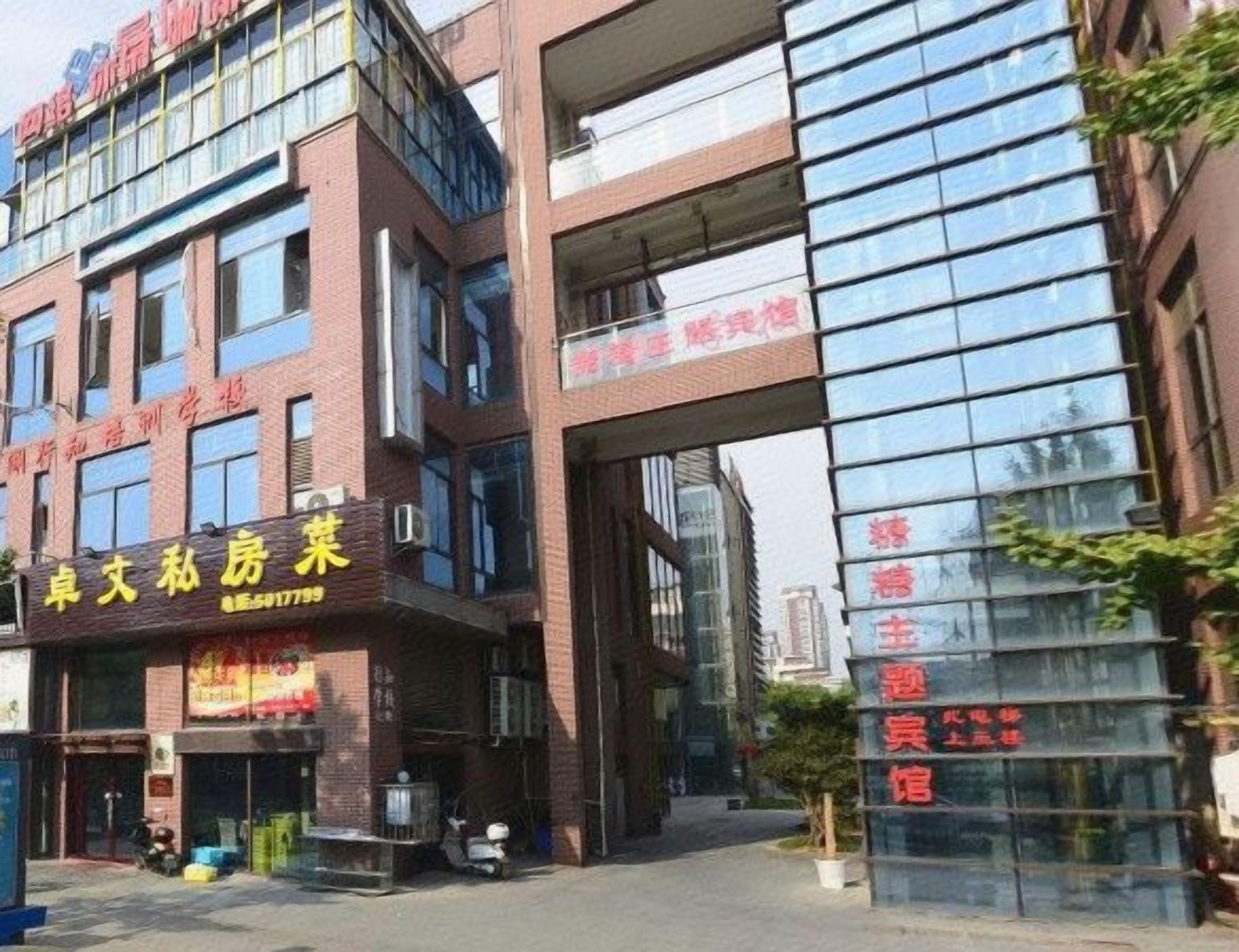 Un edificio de varios pisos con planta baja comercial y fachada de vidrio en los niveles superiores.