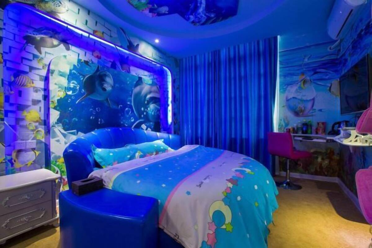 A bedroom with a bed, a desk, and a chair.