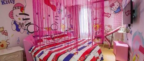 A pink-themed room with a bed, a pink chair, a desk, and a TV.