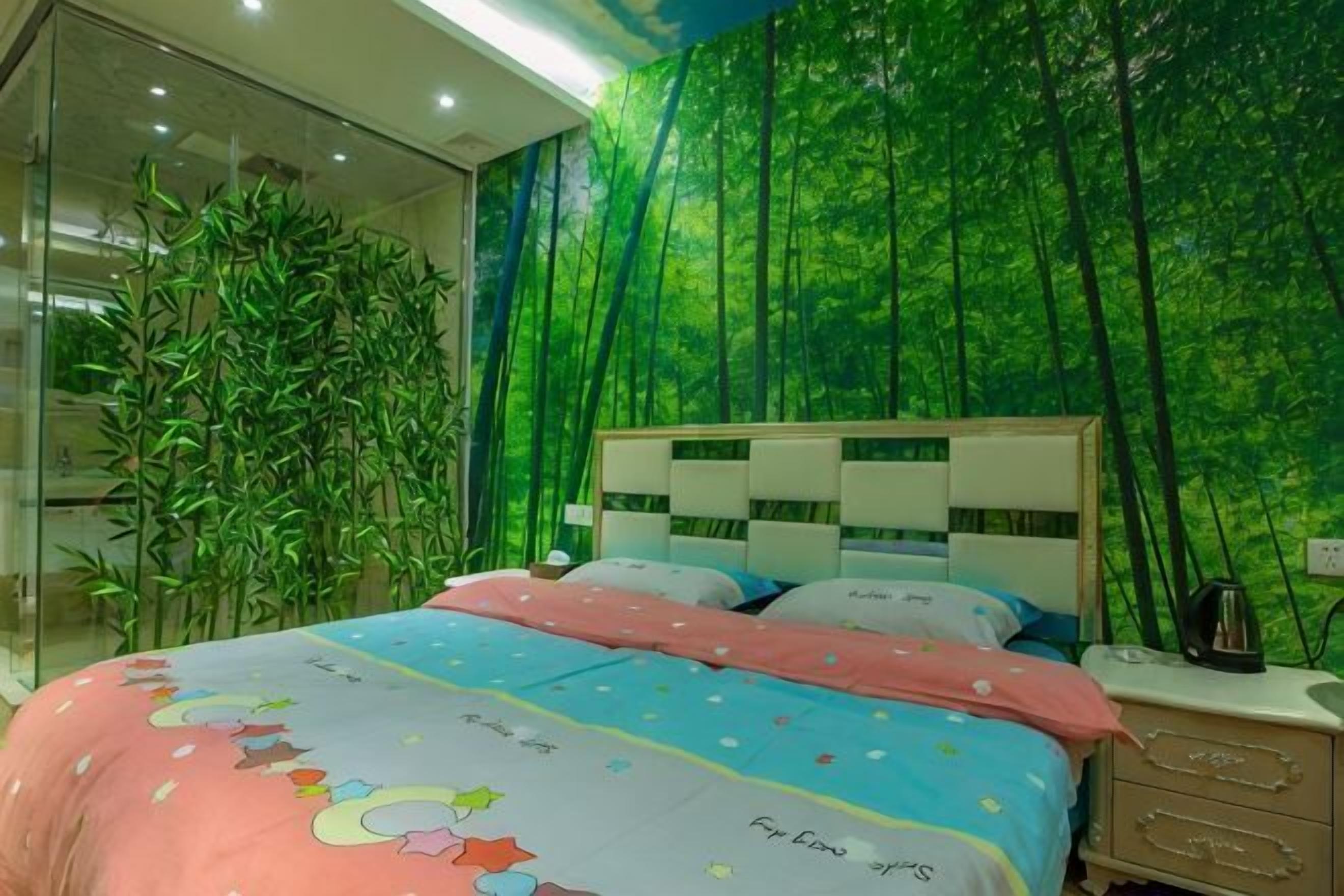 A bedroom with a bed, bedside table, and a wall mural.