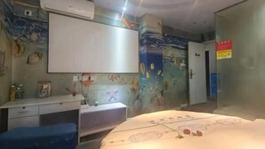 A room with a bed, a desk, a chair, an air conditioner, a wall-mounted TV, and a door with a sign. - Sugar Candy Theme Hotel (Wuhu University City Store) (Wuhu)