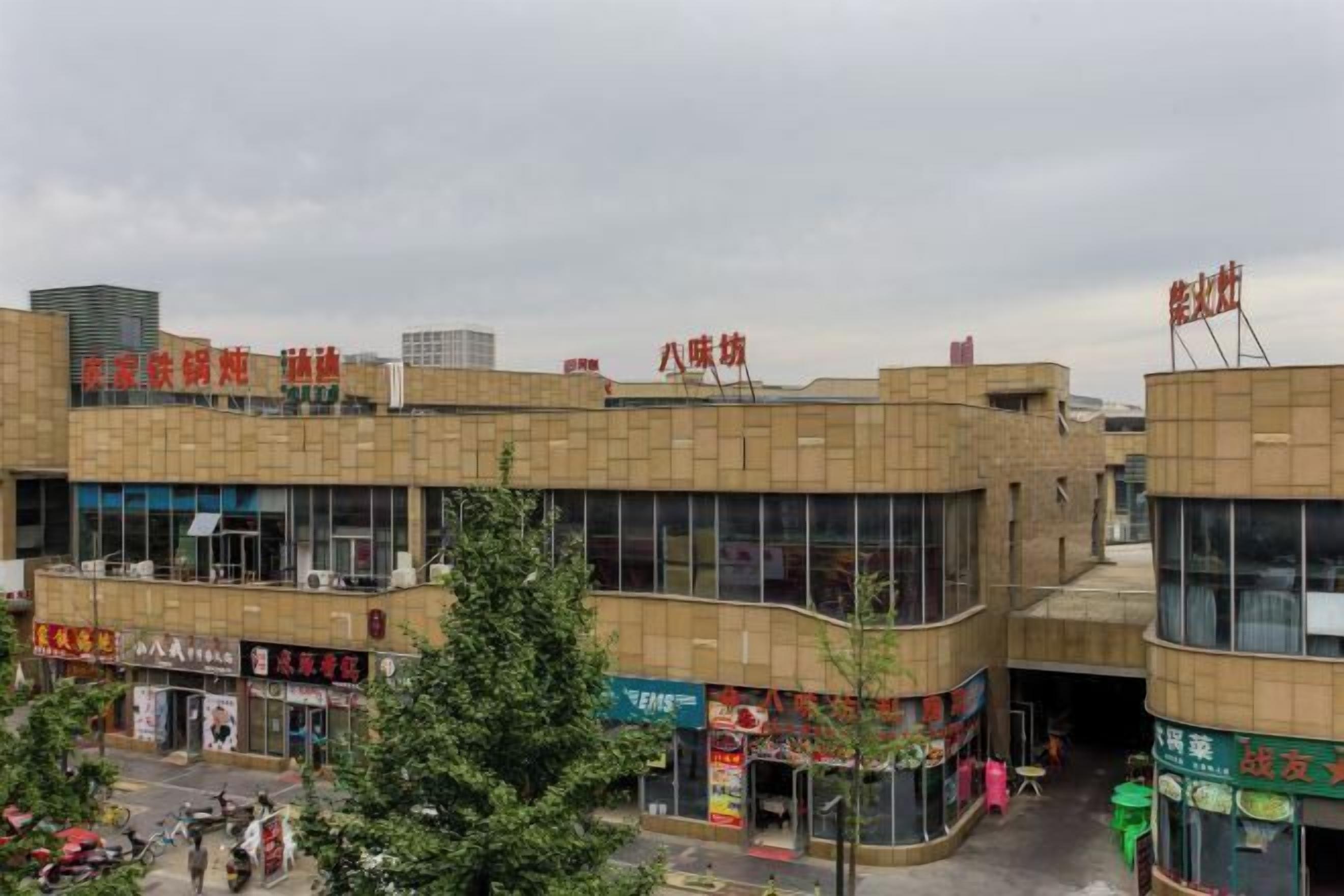 A multi-story commercial building with various storefronts on the ground floor.