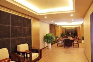 A hotel lobby with a reception desk, seating area, and a dining space. - Hanshou Inn (Guangyuan)