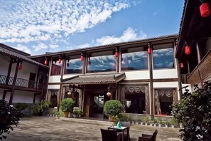 A traditional building with a courtyard, large windows, and red lanterns.